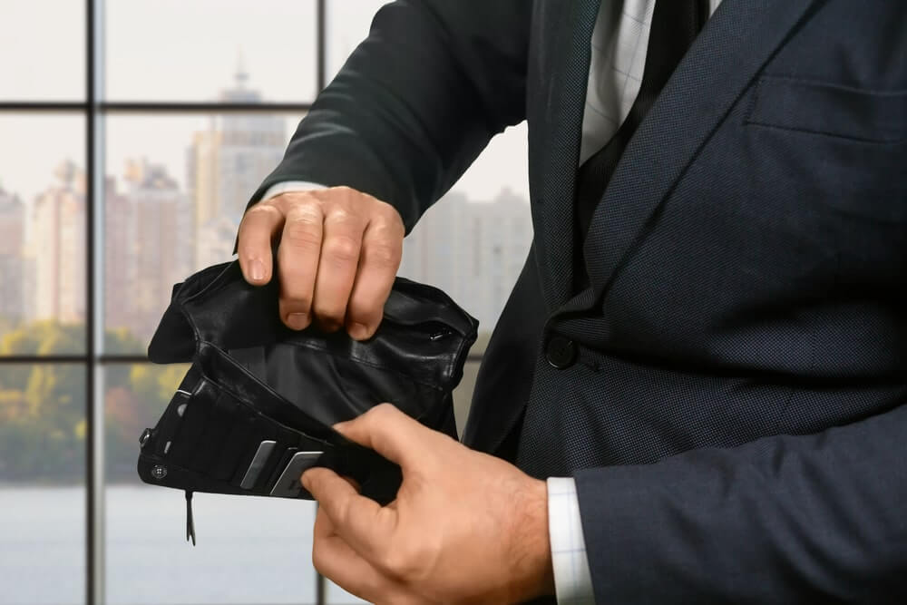 Uomo d'affari mostra il contenuto del proprio portafogli